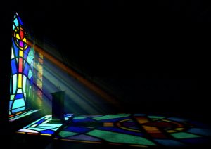 A,dim,old,church,interior,lit,by,suns,rays,penetrating